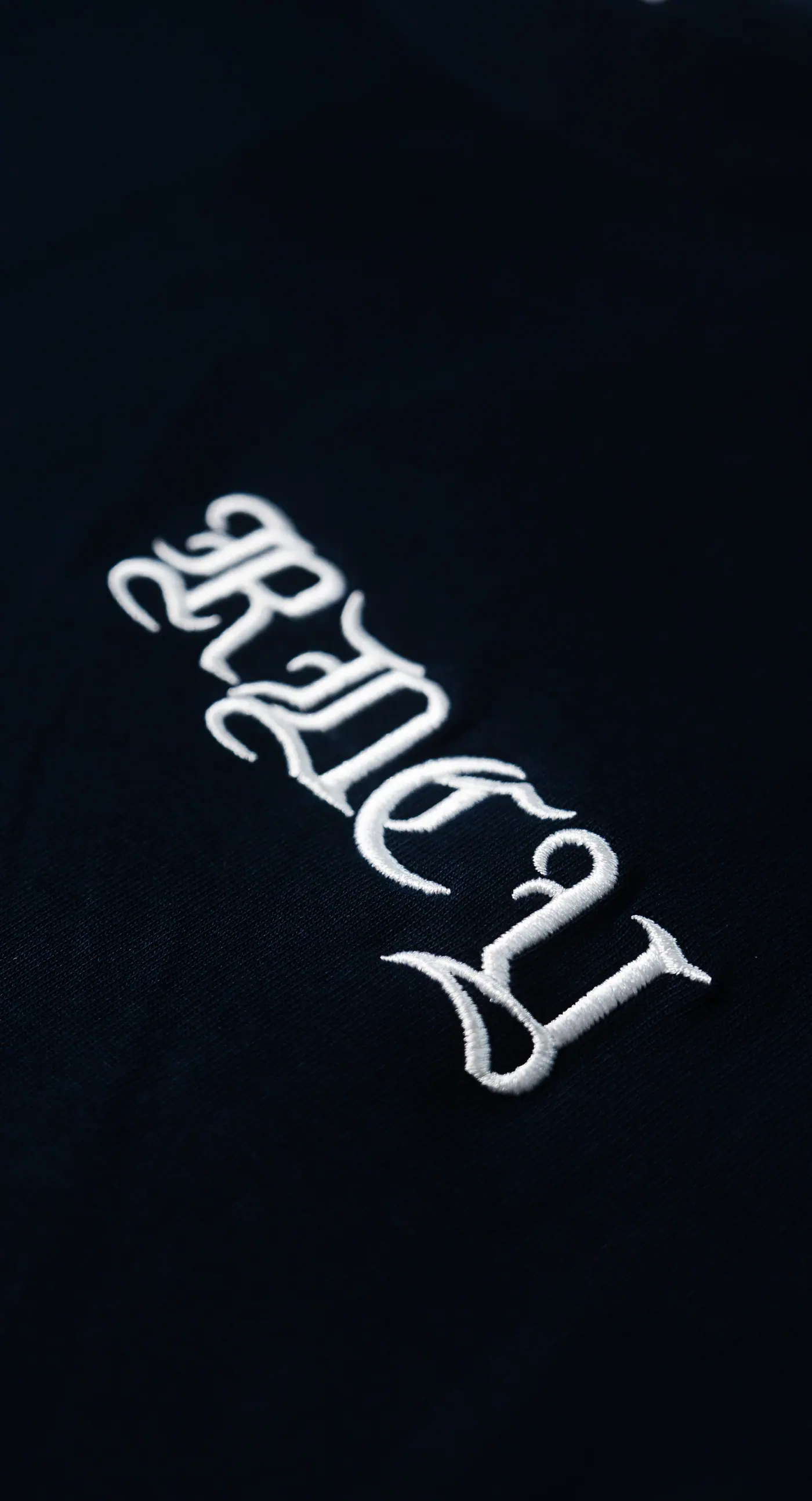 Blackletter mark stitched on black cotton