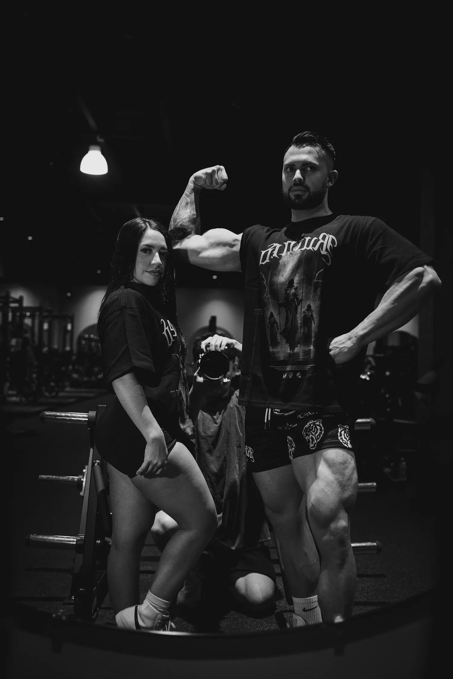 Black and white gym shot, three models in Ruined Divinity tees