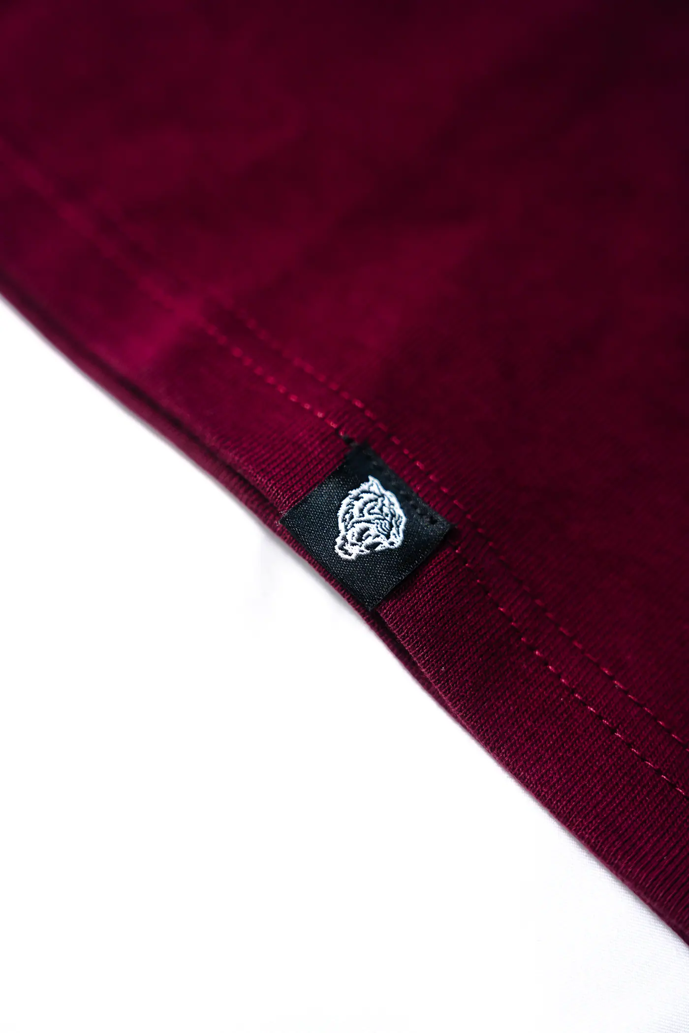 Woven side-seam label on a burgundy garment